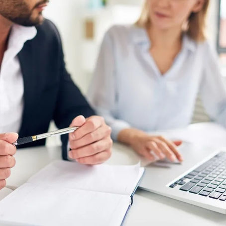 Two business professionals reviewing plans and budget allocations ahead of the end of the financial year.