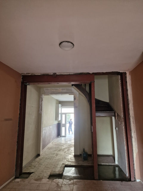 Interieur van een gebouw met een deur en trappen in aanbouw.