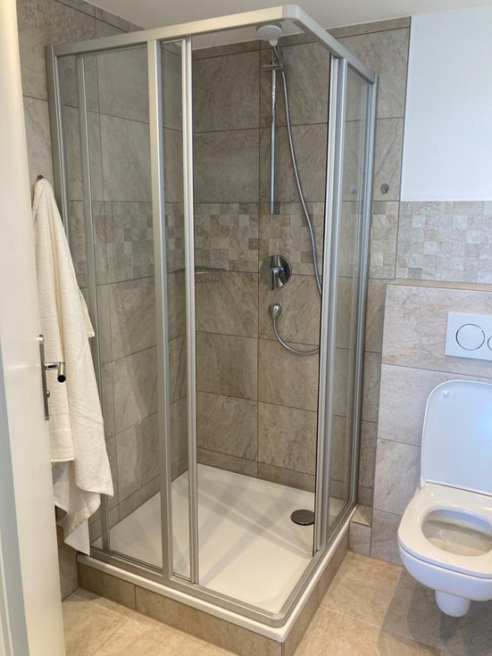 Bad mit Dusche,  Toilette und neuen Fliesen nach der Sanierung