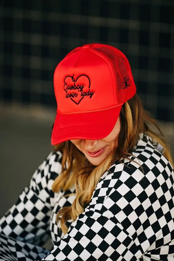 lady with blonde hair to light brown hair wearing a Red foam trucker hat with adjustable snap back