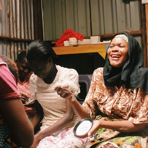 Women from Project Três in Kenya smile while making soapstone