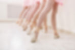 Ballet background, young ballerinas training. Little dancers legs in pointe shoes, making