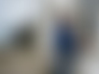 Painter working on exterior by UK coastline