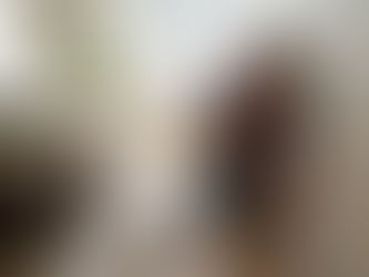 Homeowner painting skirting board in lived-in UK lounge