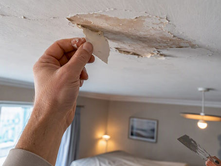 Loose paint flaking from a residential ceiling
