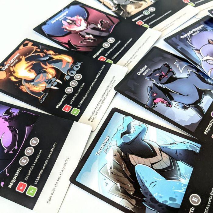 Varie carte da gioco illustrate con personaggi colorati sparsi su tavolo.