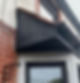 A domestic property with modern black cladding and guttering.