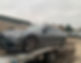 A car on the back of a tow truck.