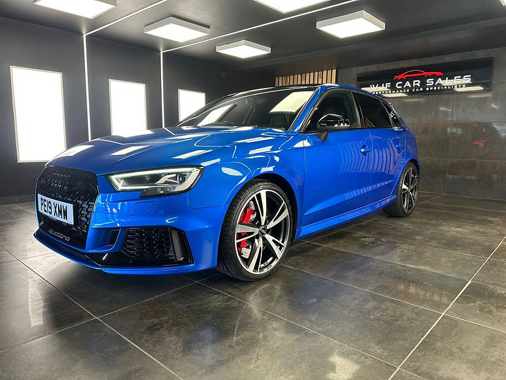 A shiny blue car in a garage.