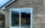 A house with white sliding doors at the back.