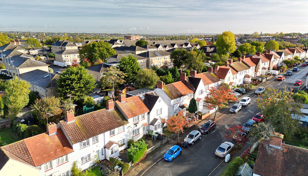 A residential street with houses and cars.