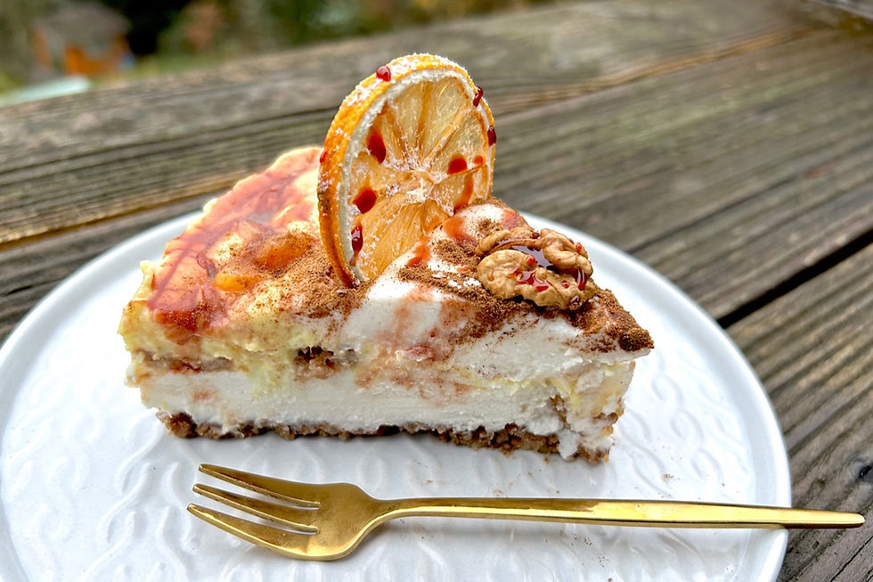 Stück veganer No-Bake-Kuchen Weihnachten mit Orangencreme, Zimt und Spekulatius auf weißem Teller, garniert mit Walnuss und kandierter Orangenscheibe.