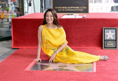 Pictured: Michelle Yeoh witting with her Walk of Fame star
