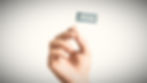 A hand holding a small flag that says "compliance"