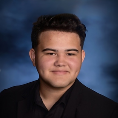 Jasper Gallas, a 17 year old boy with short black hair smiling at the camera against a blue backdrop