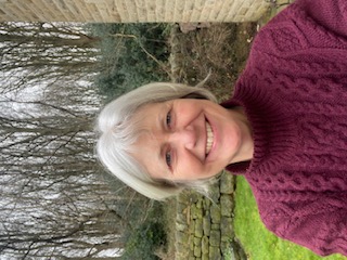 A photograph of a women with short cropped hair
