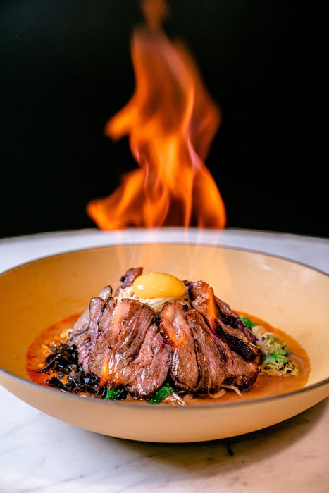 Flamed beef dish with egg yolk