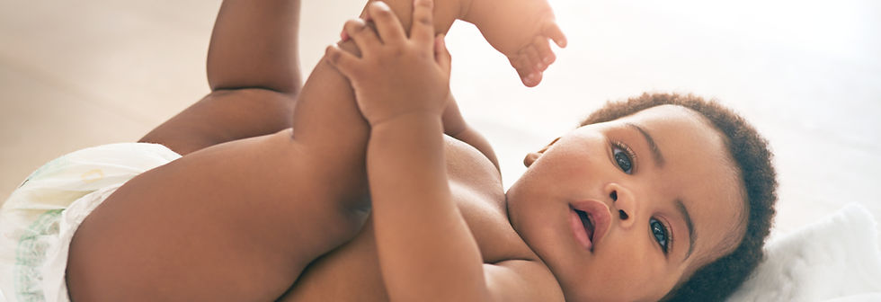 Baby laying on his back holding legs in the air