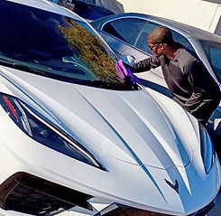 Man drying a white Corvette with a microfiber towel
