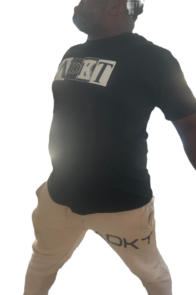 Man wearing a black shirt says ADKT, and tan pants, adkt apparel
