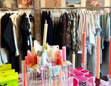 melting neon candles and sockerbit candy on table with clothing in background at fine art fruit shop in portland