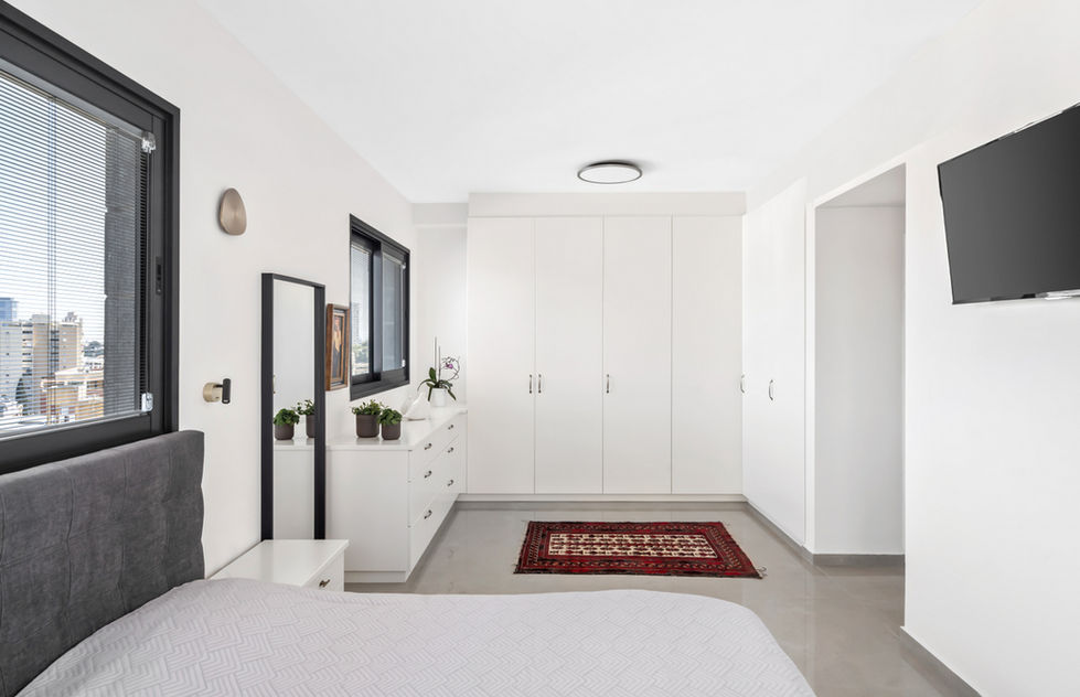 סוויטת הורים מודרנית ויוקרתית, המשלבת חדר שינה חמים עם חדר ארונות פתוח בעיצוב מוקפד.