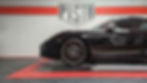porsche noire vue de côté dans le garage pista