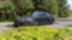 porsche noire sur route de campagne