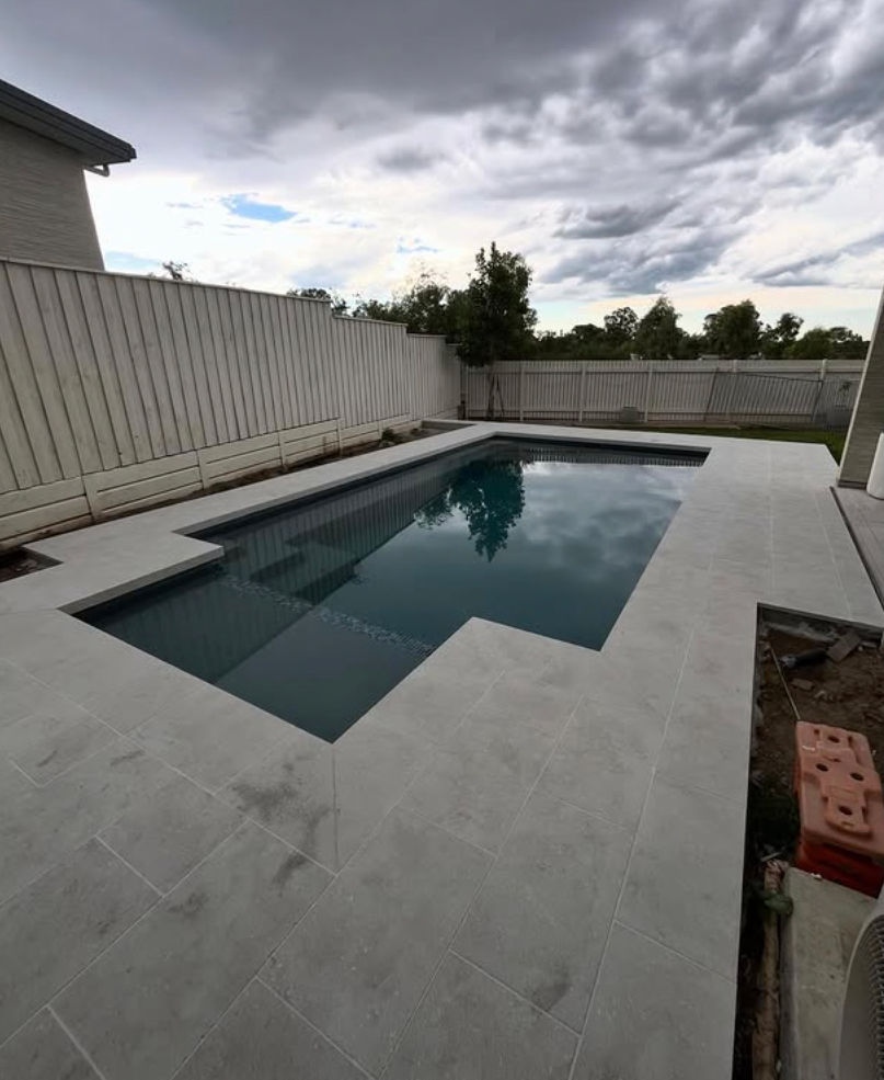 Modern family concrete pool with contemporary paving and outdoor entertaining space