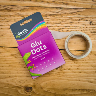 Packet of Bostick Glue Dots with the real shown next to it.