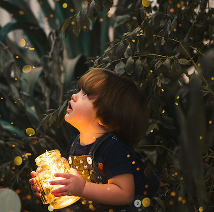 Enfant tenant un bocal rempli de guirlandes lumineuses et de souvenirs