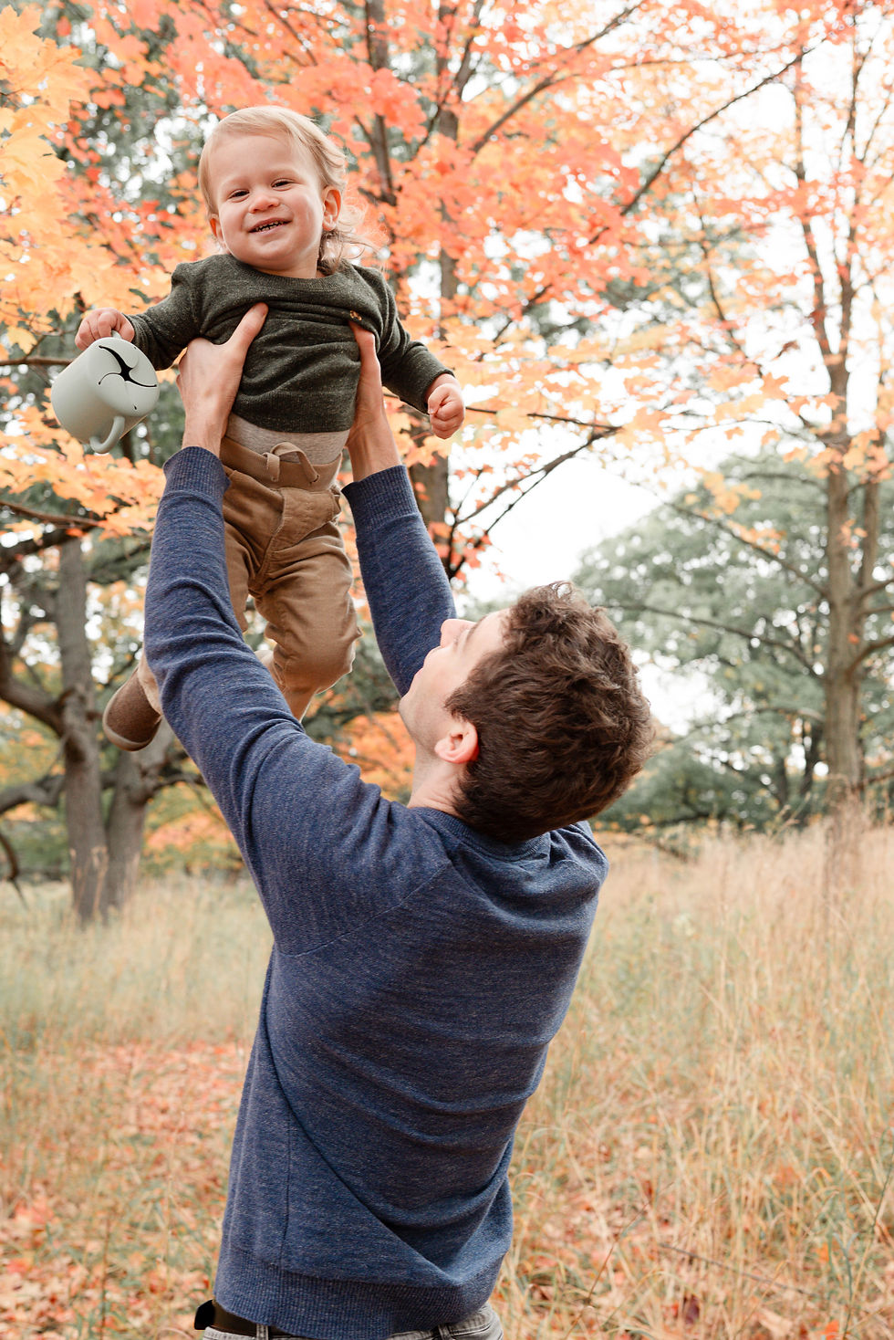 Toronto West End Photographer Dad Throwing Toddler in air after a snack