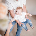 Dad-swinging-baby-towards-mom-flower-indoor-studio-toronto-family-photography.jpg