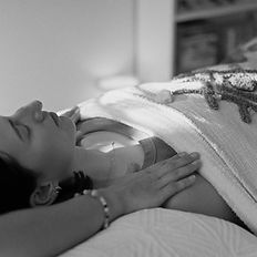 Alicia Coates offering Reiki energy healing to a woman, with her hands on her shoulders
