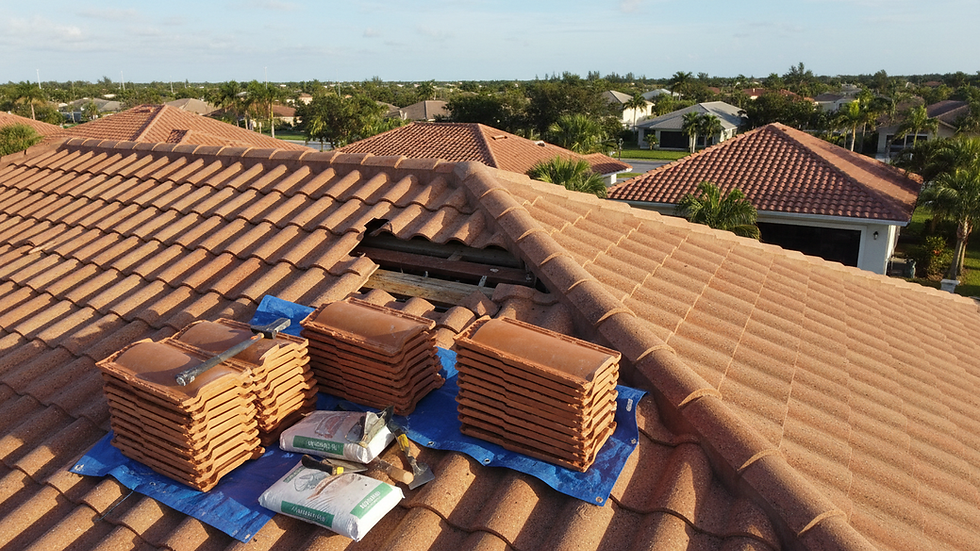 High-angle view of replacement roof tiles arranged beside a damaged tile area