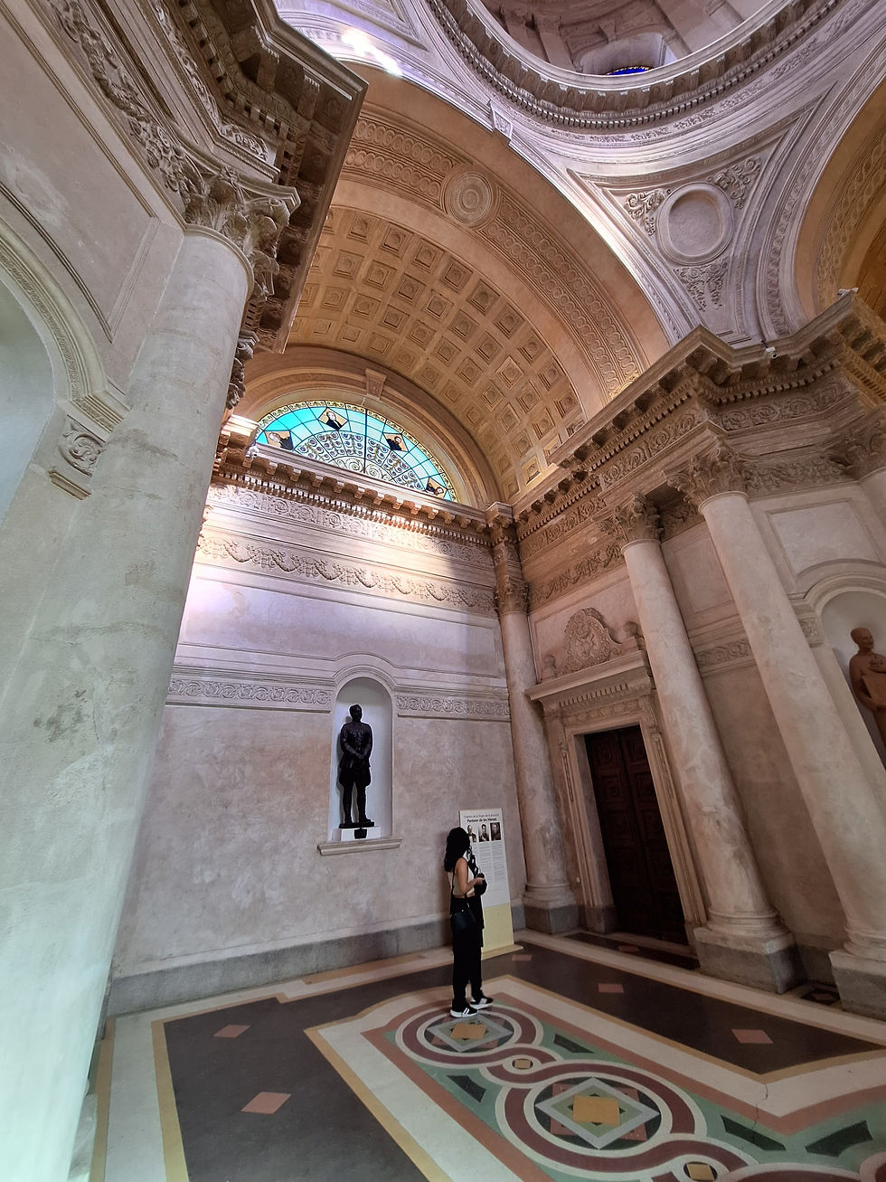 Fotografía en ángulo contrapicado que muestra los imponentes arcos y cúpulas de piedra labrada en el interior de una catedral clásica, con un gran ventanal de cristal con tonos celestes e iluminación natural que evoca una sensación de amplitud y búsqueda interna.