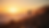 Eye-level view of a couple walking along Newport’s rocky coastline at sunset