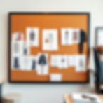 Fashion mood board with sketches of outfits pinned on an orange board. Neutral-toned room with a framed coat and scarf on a chair.