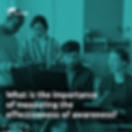 The image depicts a corporate environment with four professionals gathered around a computer, collaboratively analyzing information on the screen. The individuals are focused, some standing and others sitting, suggesting a joint discussion or evaluation of data. The scene conveys a context of analytical work and decision-making, with typical office elements in the background.