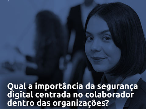 Foto de uma mulher de cabelo escuro e liso olhando para a câmera, com expressão neutra e leve sorriso. Ao fundo, pessoas desfocadas interagem em um ambiente corporativo.