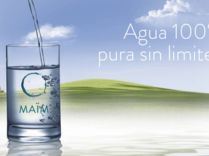 Vaso con el logo de MAÏM llenándose de agua fresca frente a un paisaje verde y cielo azul. Texto en la imagen: Agua 100% pura sin limites. Solución ideal de purificador de agua Costa Rica.