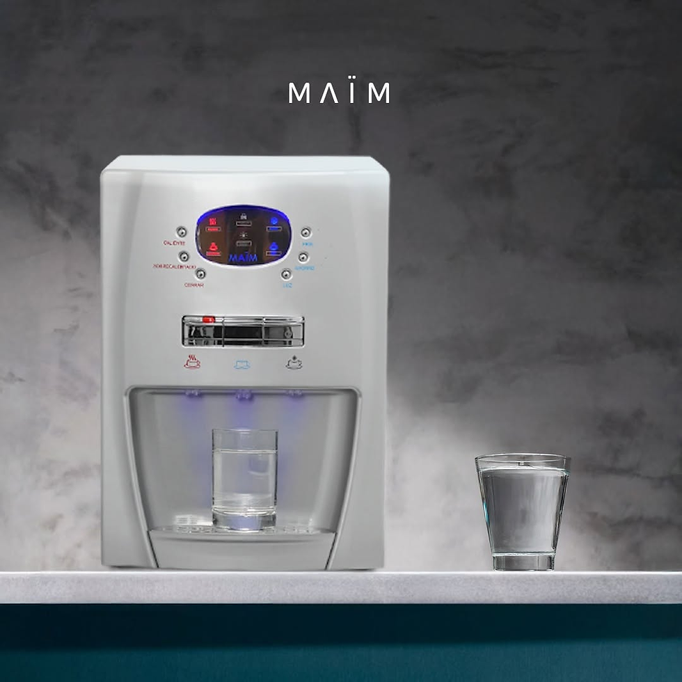 Purificador de agua MAÏM blanco con panel touch digital iluminado sobre una encimera moderna, junto a vasos de cristal con agua recién servida.