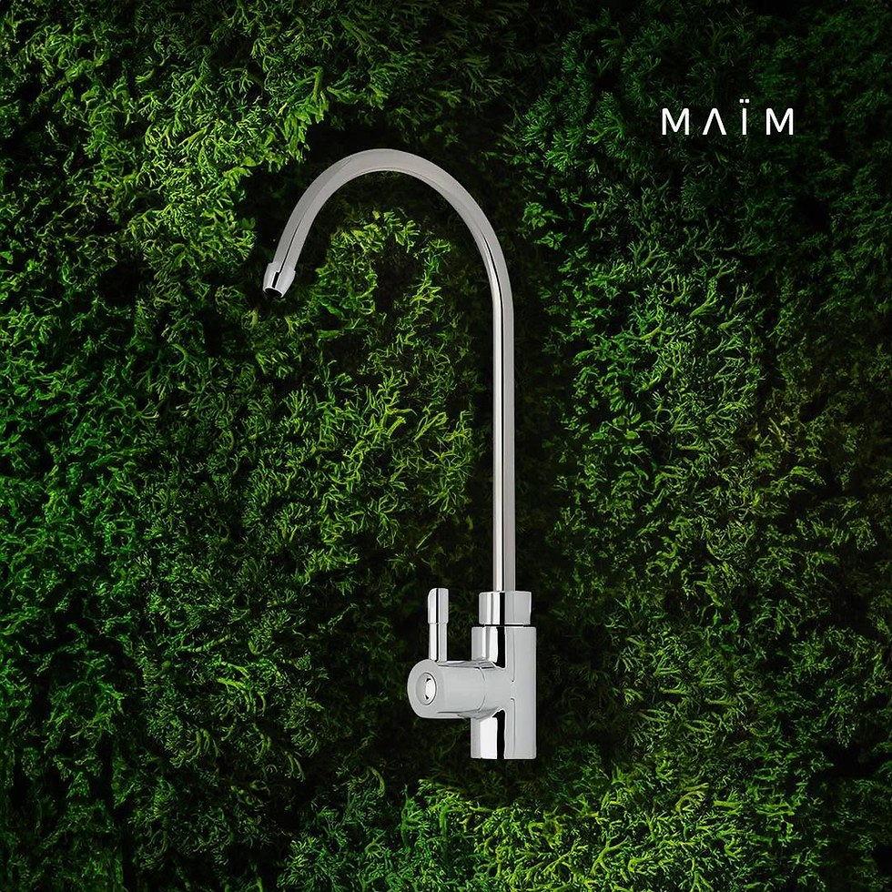 Elegante grifo cromado de filtros de agua MAÏM sobre un fondo de musgo verde natural, representando la frescura y sostenibilidad de la ultrafiltración.