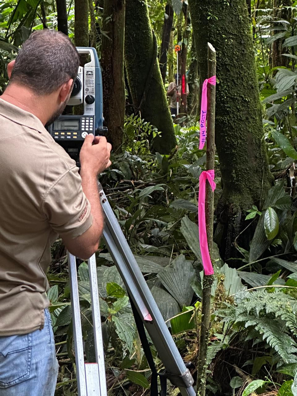 Ingeniero de Consultécnicos realizando medición con estación total en terreno con densa vegetación para determinar cuánto cobra un topógrafo en Costa Rica según la complejidad del relieve.