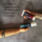 Vegan Tattoo Skin Care aftercare cream tube held by a hand next to a floral arm tattoo with text Protect Your Art
