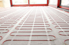 Electric underfloor heating red mats on cement floor. Heating red electrical cable on ceme