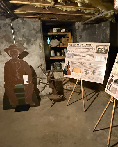 Enslaved quarters exhibit at Mabry-Hazen House with text panel and life-sized silhouette