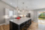 Modern kitchen island with seating, white cabinets, and stainless steel appliances