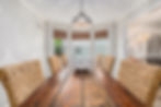 Rustic wooden dining table with wicker chairs