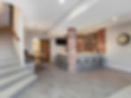 Finished basement bar with brick wall, stools, and stairs